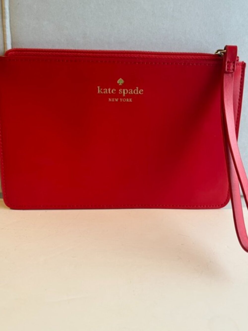 Kate Spade New York small red leather wristlet.